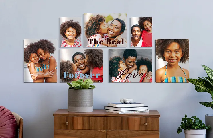 ["Metal Photo Print by Printerpix","Aluminium photo print of a mountain and a lake, held by a woman, produced by Printerpix","Small square metal print of a man diving into a lake","Metal photo print of a mother and daughter on a bookshelf","Woman placing metal print of girlfriend and boyfriend on the wall","Three metal prints in different sizes","","","",""]||||||||||