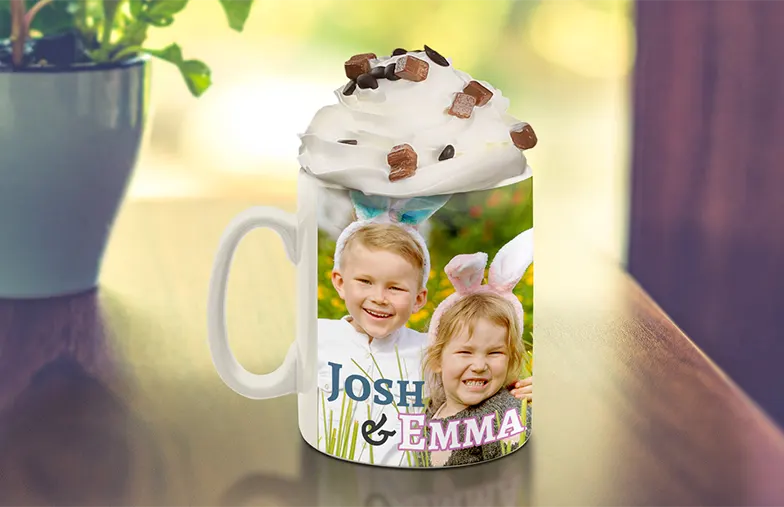 ["Personalised photo mugs from Printerpix", "Mum and baby holding a mug with a cartoon design from Printerpix and the caption 'Dad'", "Personalised photo mug with a picture of a crawling baby in an animal onesie", "Mum and daughter holding custom photo mugs with family pictures", "Kissing couple with personalised mugs featuring text", "Personalised photo mug with your own photo of a dog on it", "", "", "", "", ""]||||||||||