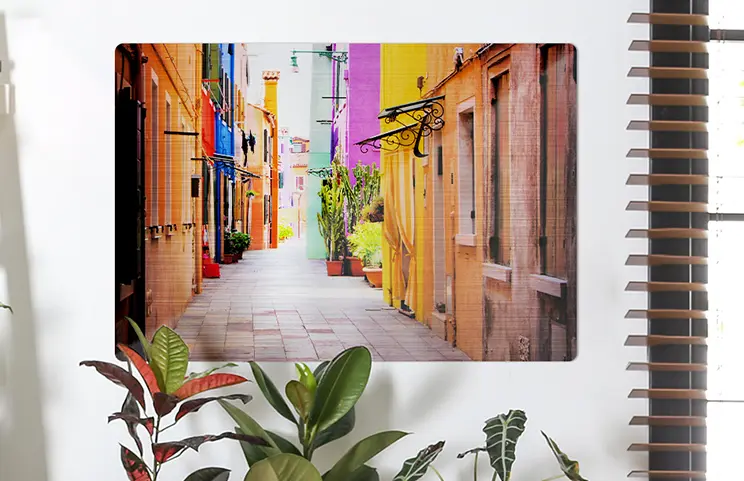 Metal photo print by Printerpix|Aluminium photo print of a mountain and a lake, held by a woman, produced by Printerpix|Small square metal print of a man diving into a lake|Metal print of mother and daughter on bookshelf|Woman hangs metal print of girlfriend and boyfriend on the wall|Three metal prints in different sizes|||||