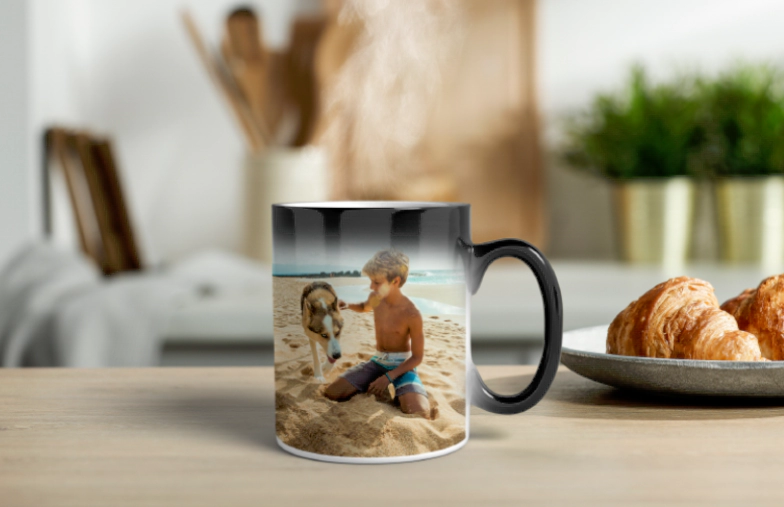 ["Printerpix Magic Mug with Personal Baby Photo that Appears When Heated", "Printerpix Magic Mug with Personal Baby Photo that Appears When Heated", "Young Boy Holding a Custom Magic Mug with His Own Photo on It", "Magic Mug with Cat Photo, Pouring Tea at a Desk", "Couple Holding Two Heat-Sensitive Magic Mugs with Custom Text from Printerpix", "Personalized Magic Mug with Revealed Photo of a Young Woman", "", "", "", ""]||||||||||