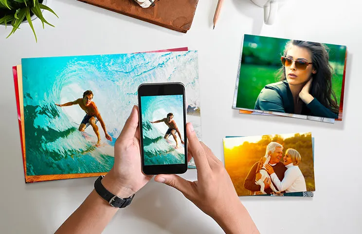 Kleine, mittlere und große Fotoabzüge auf einem Tisch vom Mobiltelefon