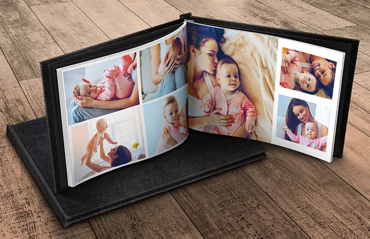 Individuell gestaltetes Fotoalbum, geöffnet auf dem Tisch, mit einer Fotocollage von Familienfotos