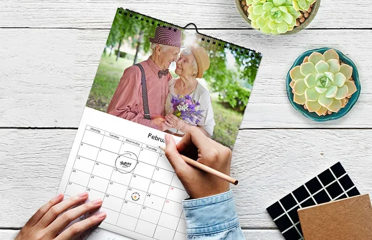 Frau schreibt auf einem A4-kundenspezifischen Wandkalender von Printerpix mit Weihnachtsmotivfoto