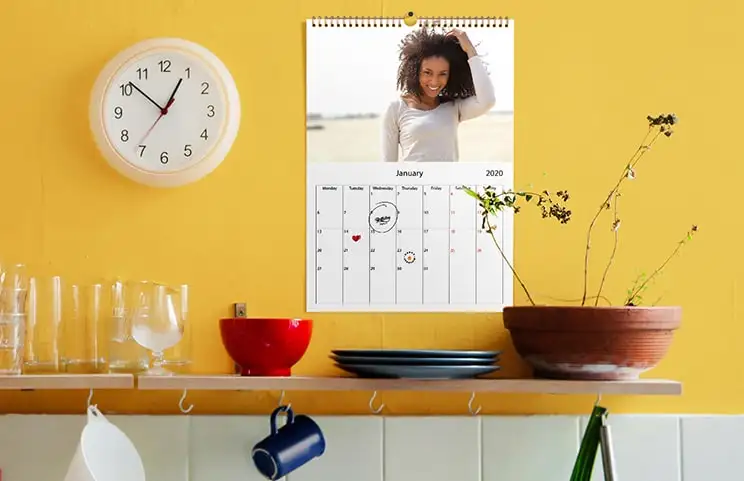 Romantisches Paar im Wohnzimmer mit personalisiertem 2020 Wandkalender mit Verlobungsfoto