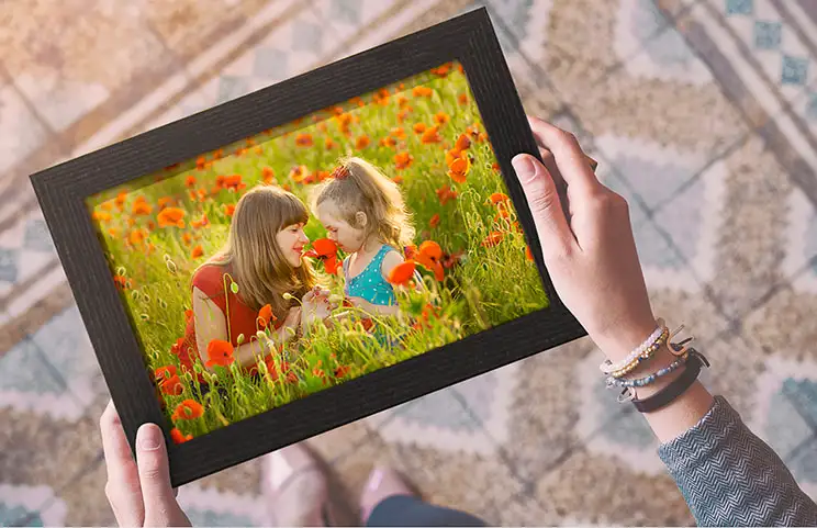 Hand holding framed photo of mother and daughter