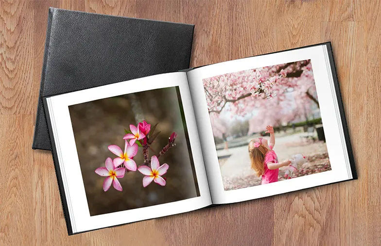 Paar betrachtet ein individuell gestaltetes Fotobuch mit Ledereinband von Printerpix