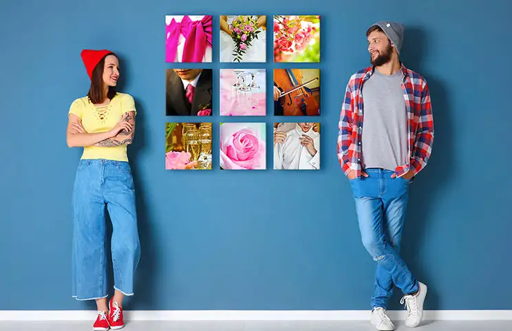 Couple in front of a blue wall with nine square photo canvases
